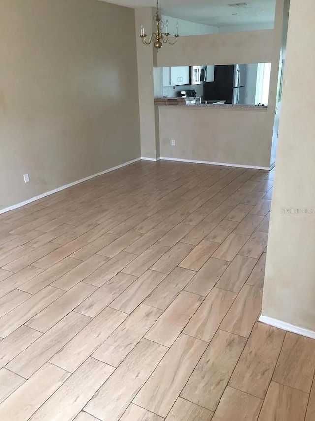 244 Countryside Key Blvd, Oldsmar, FL 34677 - unfurnished living room featuring wood tiled floors, a chandelier, and baseboards