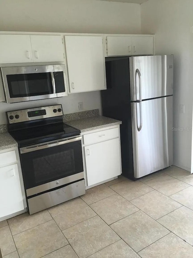 244 Countryside Key Blvd, Oldsmar, FL 34677 - kitchen with stainless steel appliances, light tile patterned flooring, and white cabinets