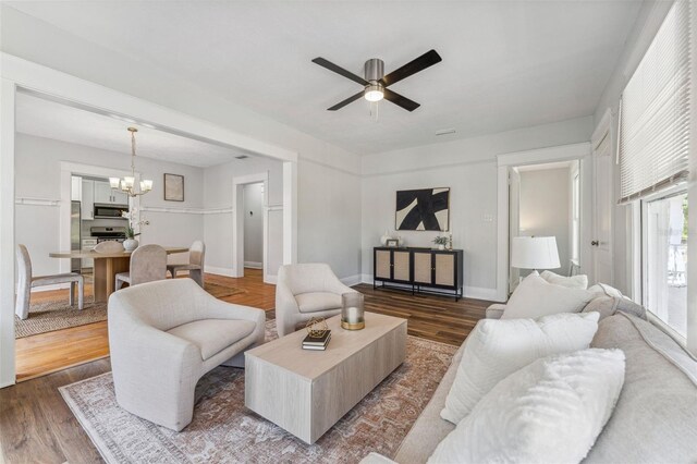 307 S Newport Ave, Tampa, FL 33606 - living room featuring baseboards, wood finished floors, and ceiling fan with notable chandelier