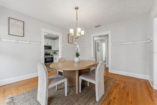 307 S Newport Ave, Tampa, FL 33606 - dining room with a chandelier, visible vents, baseboards, and light wood-style flooring
