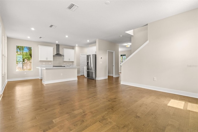 unfurnished living room with baseboards, recessed lighting, wood finished floors, and visible vents