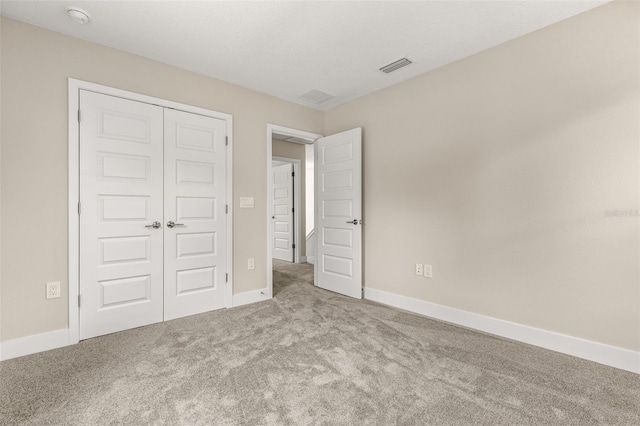 unfurnished bedroom with a closet, baseboards, carpet flooring, and visible vents