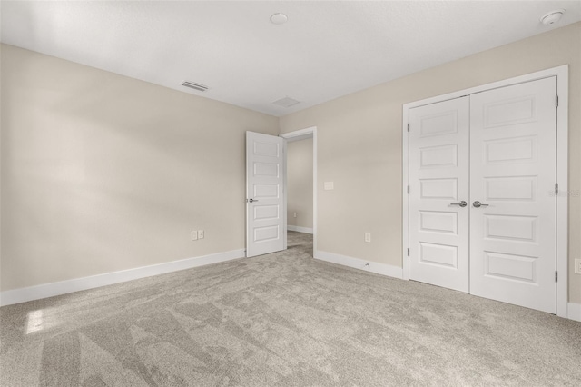 unfurnished bedroom with carpet floors, baseboards, a closet, and visible vents