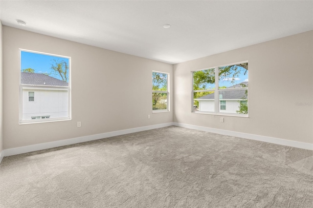 carpeted empty room with baseboards