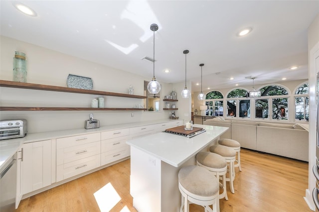 2802 Old Bayshore Way, Tampa, FL 33611 - kitchen with open shelves, a center island, white cabinetry, a breakfast bar area, and light countertops