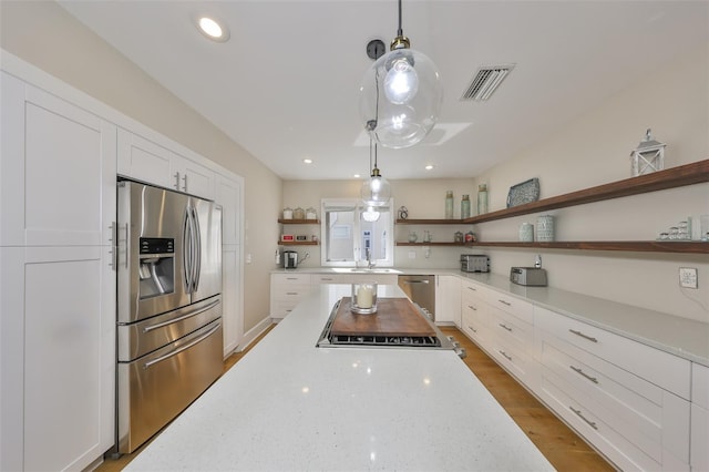2802 Old Bayshore Way, Tampa, FL 33611 - kitchen featuring open shelves, appliances with stainless steel finishes, white cabinetry, light stone counters, and hanging light fixtures