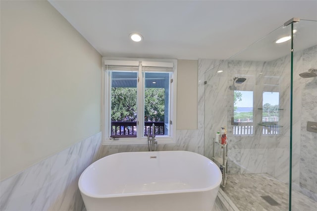 2802 Old Bayshore Way, Tampa, FL 33611 - bathroom with tile walls, a soaking tub, a marble finish shower, and recessed lighting