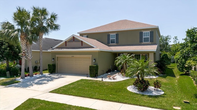 view of front of home featuring an attached garage, driveway, stucco siding, and a front yard