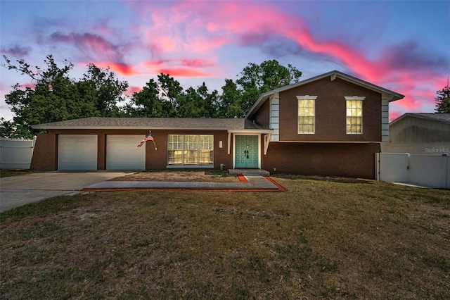 613 Valley Hill Dr, Brandon, FL 33510 - tri-level home with concrete driveway, an attached garage, stucco siding, and a gate