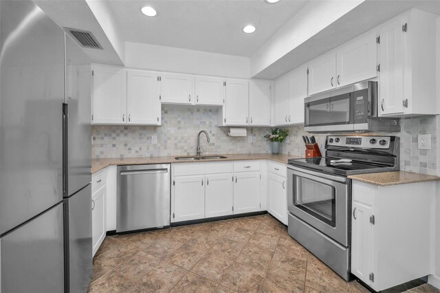 613 Valley Hill Dr, Brandon, FL 33510 - kitchen featuring appliances with stainless steel finishes, a sink, light stone countertops, white cabinets, and tasteful backsplash