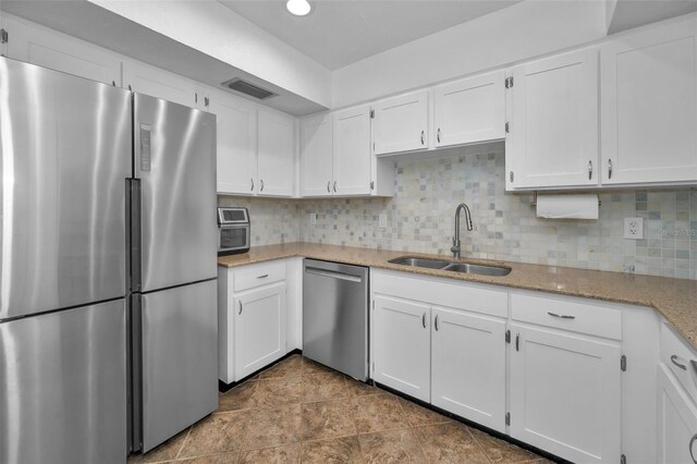 613 Valley Hill Dr, Brandon, FL 33510 - kitchen with appliances with stainless steel finishes, a sink, white cabinets, and light stone countertops