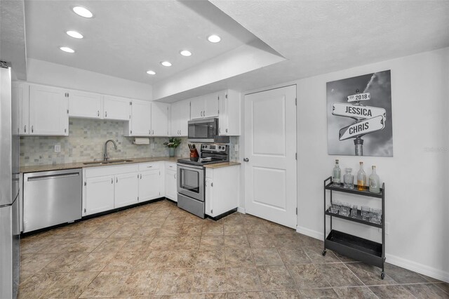 613 Valley Hill Dr, Brandon, FL 33510 - kitchen with stainless steel appliances, a sink, baseboards, white cabinets, and recessed lighting