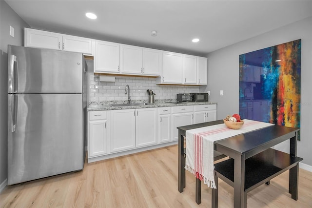 613 Valley Hill Dr, Brandon, FL 33510 - kitchen featuring freestanding refrigerator, a sink, light wood-type flooring, white cabinets, and recessed lighting