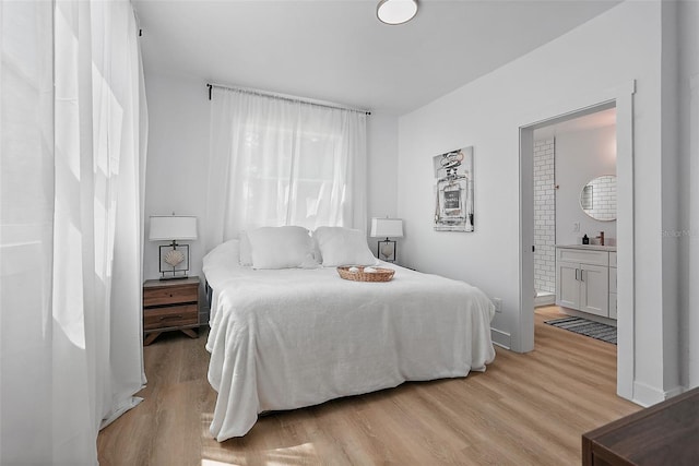 3000 19th Ave S, Saint Petersburg, FL 33712 - bedroom with light wood-style flooring, ensuite bath, and baseboards