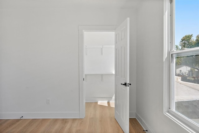 3000 19th Ave S, Saint Petersburg, FL 33712 - unfurnished bedroom with light wood-style flooring, a walk in closet, a closet, and baseboards