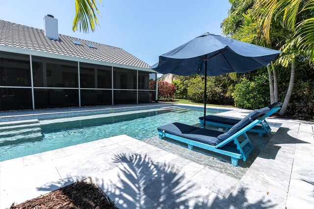 outdoor pool featuring a sunroom and a patio