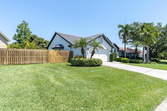 view of property exterior featuring concrete driveway, fence, a garage, a yard, and stucco siding