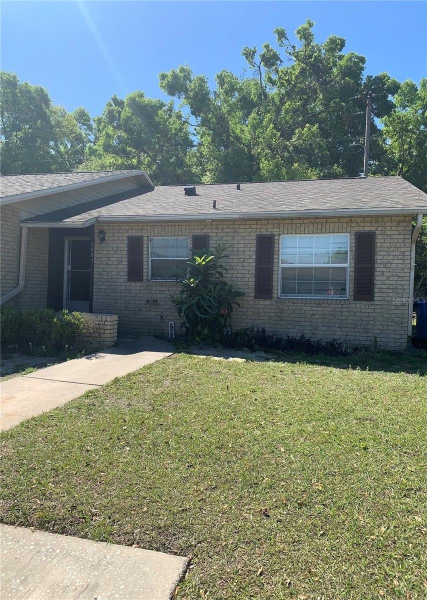 9501 Lake Park Dr Unit 9501, Thonotosassa, FL 33592 - ranch-style home with roof with shingles, a front lawn, and brick siding