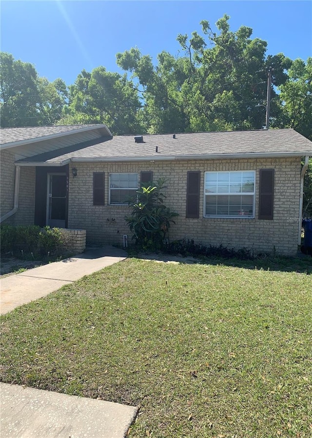 9501 Lake Park Dr Unit 9501, Thonotosassa, FL 33592 - ranch-style home with roof with shingles, a front lawn, and brick siding