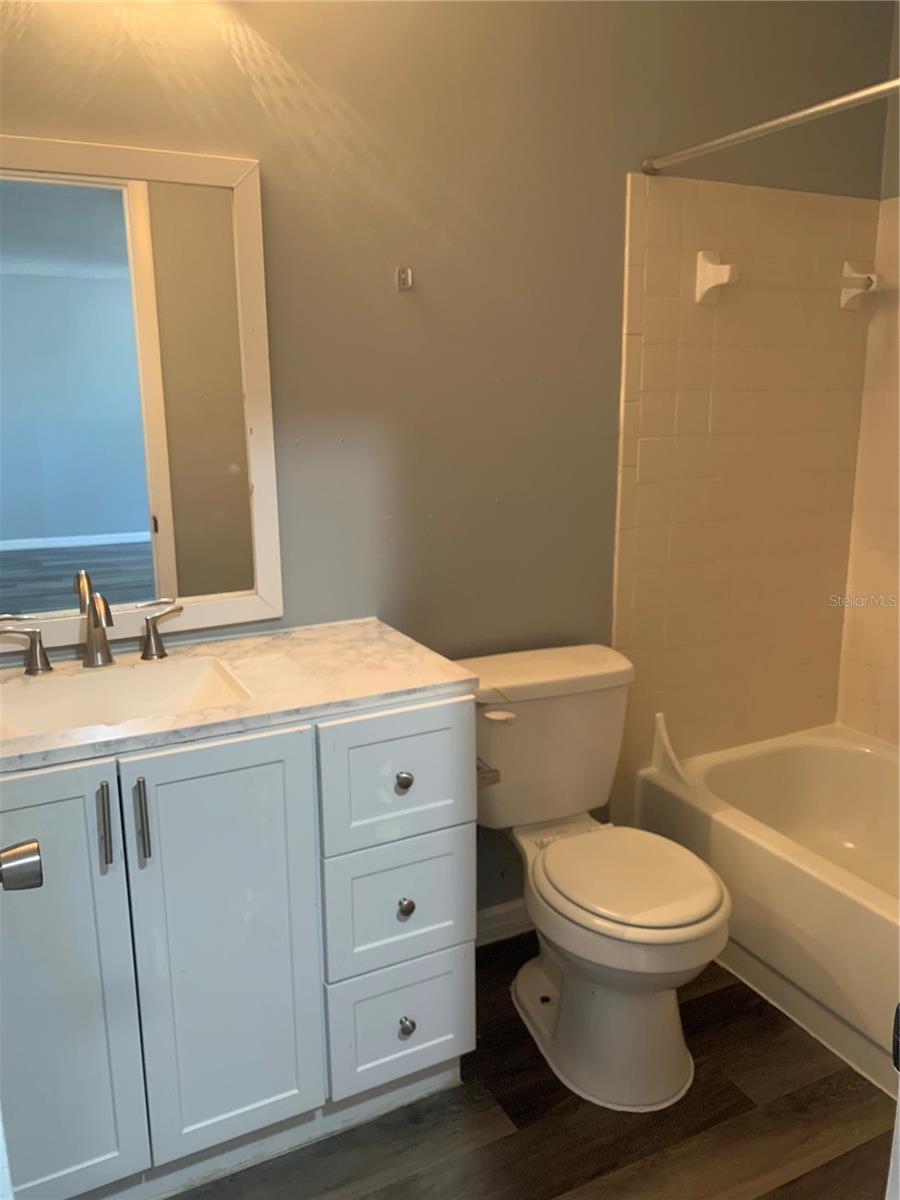 9501 Lake Park Dr Unit 9501, Thonotosassa, FL 33592 - bathroom featuring vanity, shower / tub combination, toilet, and wood finished floors