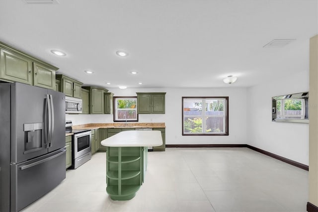 11797 David Ct, Largo, FL 33778 - kitchen with green cabinets, appliances with stainless steel finishes, healthy amount of natural light, light countertops, and recessed lighting
