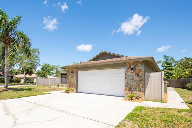 11797 David Ct, Largo, FL 33778 - view of front of house with stone siding, driveway, and a garage
