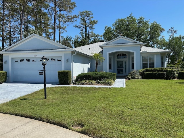 11752 Wayside Willow Ct, Hudson, FL 34667 - view of front of home featuring driveway, a front yard, an attached garage, and stucco siding