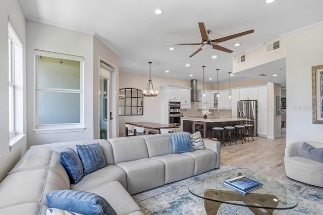 living area featuring a ceiling fan, visible vents, and plenty of natural light