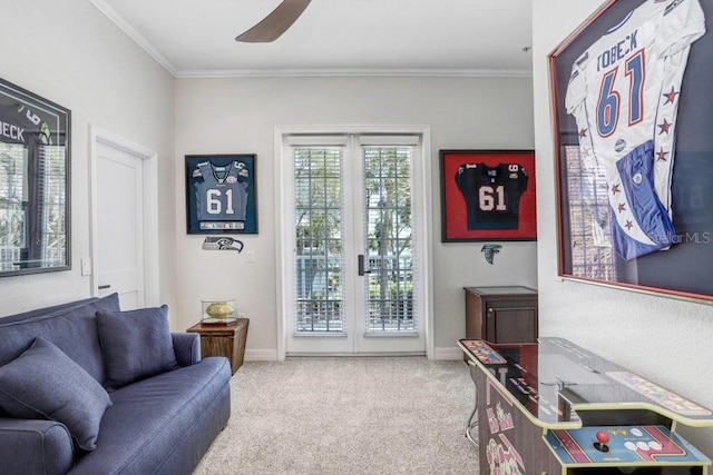sitting room featuring ceiling fan, baseboards, ornamental molding, and carpet floors