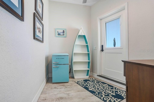 doorway with wood finished floors and baseboards