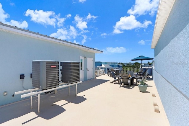 view of patio featuring outdoor dining area and central AC