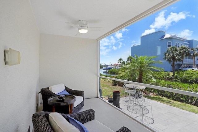 balcony with a ceiling fan and a water view