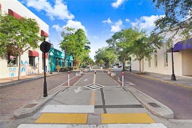 view of street featuring traffic signs, sidewalks, and curbs