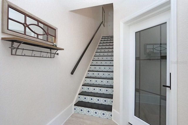 stairway featuring baseboards and wood finished floors