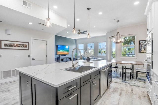 kitchen with plenty of natural light, dishwasher, a sink, and visible vents