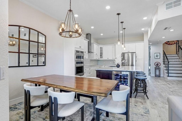 dining space featuring visible vents, ornamental molding, baseboards, stairway, and a notable chandelier