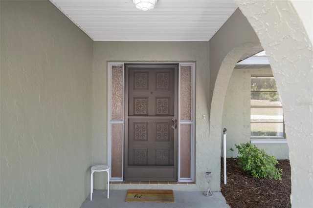 entrance to property featuring stucco siding