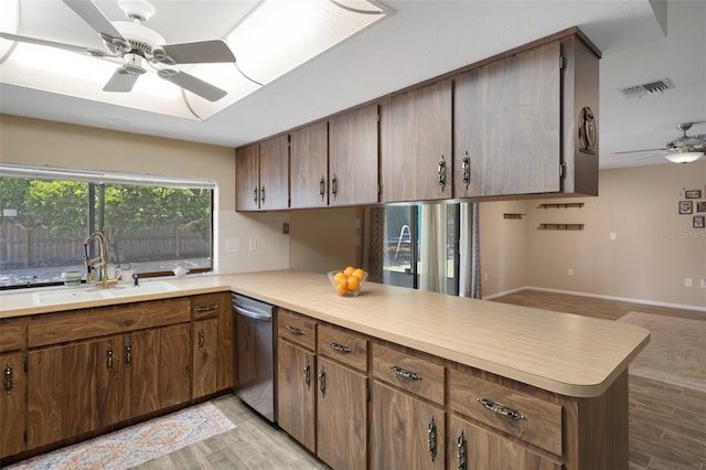 kitchen featuring visible vents, stainless steel dishwasher, a sink, a peninsula, and ceiling fan