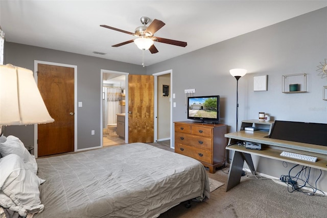 carpeted bedroom with ceiling fan, ensuite bath, visible vents, and baseboards
