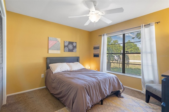 carpeted bedroom with a ceiling fan and baseboards