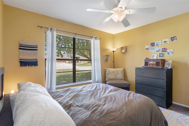 carpeted bedroom featuring baseboards and a ceiling fan