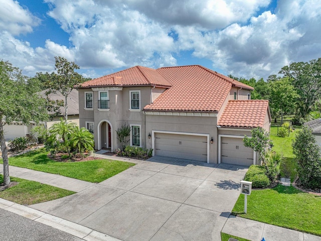 mediterranean / spanish home featuring a tile roof, a garage, stucco siding, a front yard, and driveway