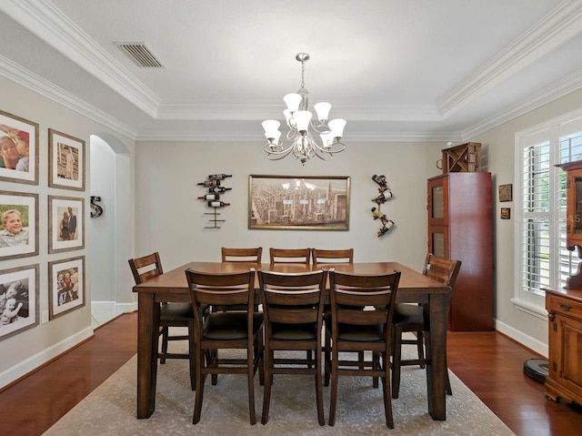 dining space featuring visible vents, arched walkways, a chandelier, and dark wood-style floors