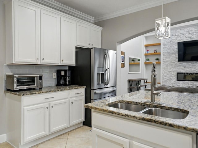 kitchen featuring a sink, light stone counters, a toaster, ornamental molding, and white cabinetry