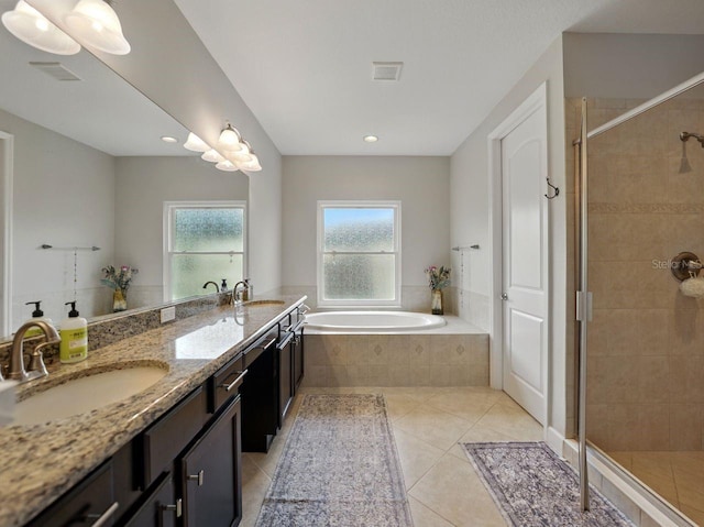 bathroom with tile patterned floors, a shower stall, a sink, and a garden tub