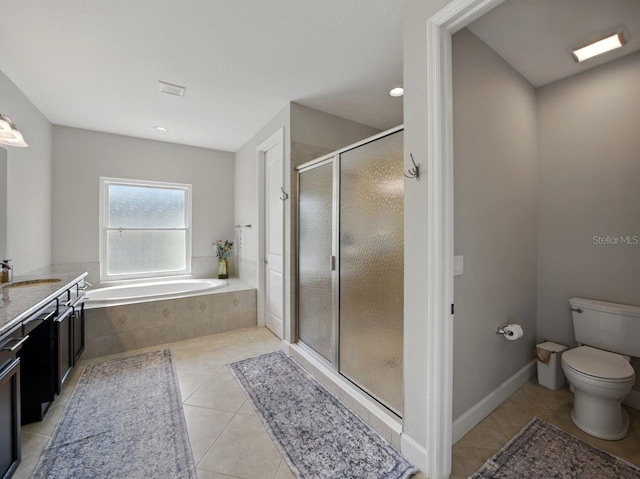 bathroom featuring vanity, toilet, tile patterned floors, a garden tub, and a stall shower