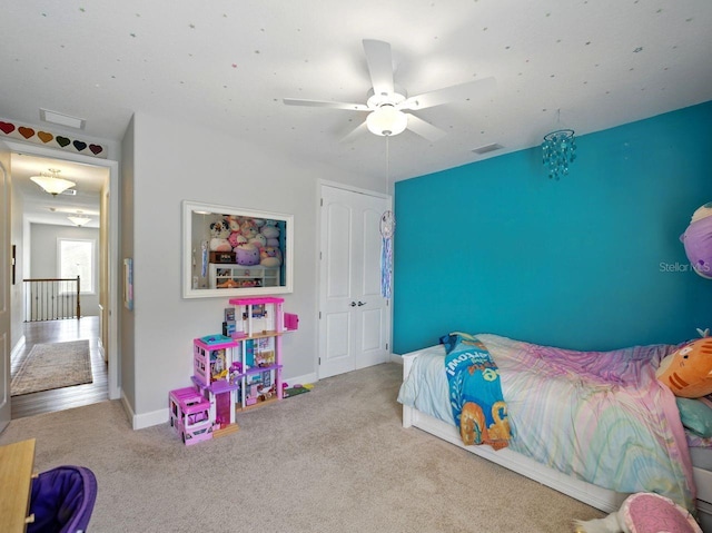 carpeted bedroom with a ceiling fan, baseboards, and visible vents