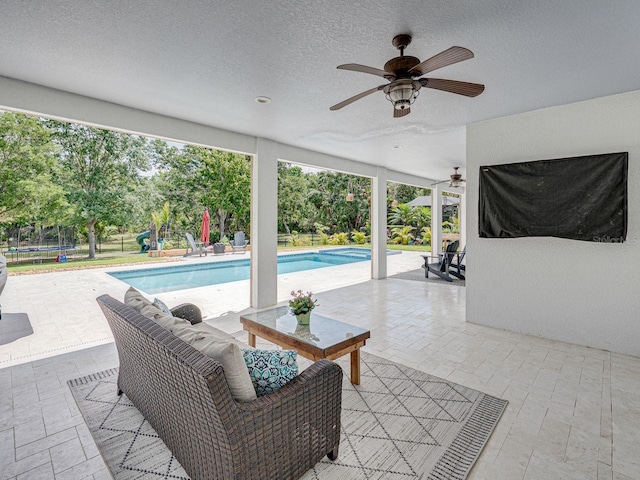 outdoor pool featuring a playground, a ceiling fan, a patio area, and a trampoline