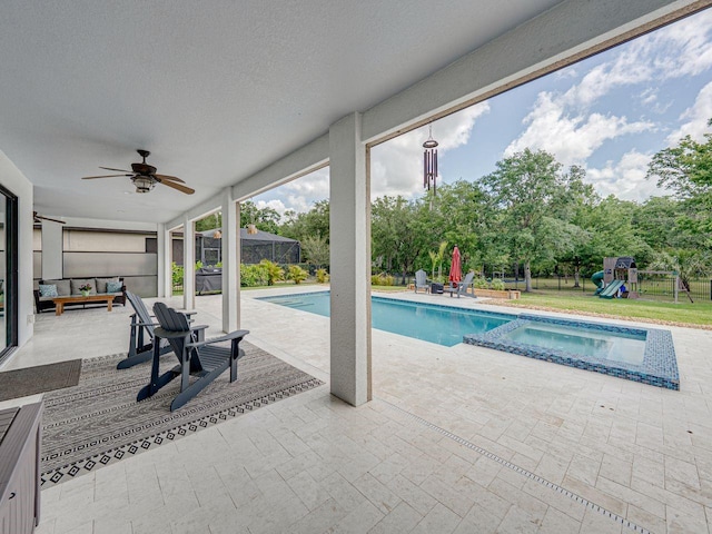 view of pool with ceiling fan, a pool with connected hot tub, a patio area, fence, and a playground