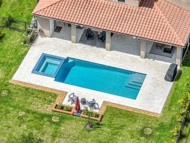 view of pool with a yard, a patio, a pool with connected hot tub, and fence